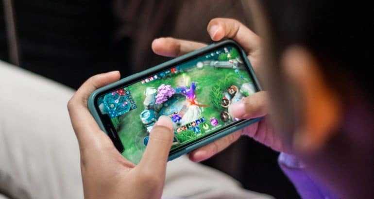 Pessoa jogando videogame no celular em posição horizontal