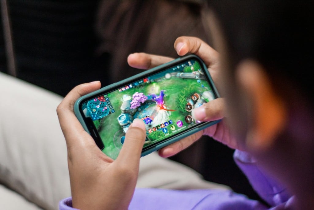 Pessoa jogando videogame no celular em posição horizontal