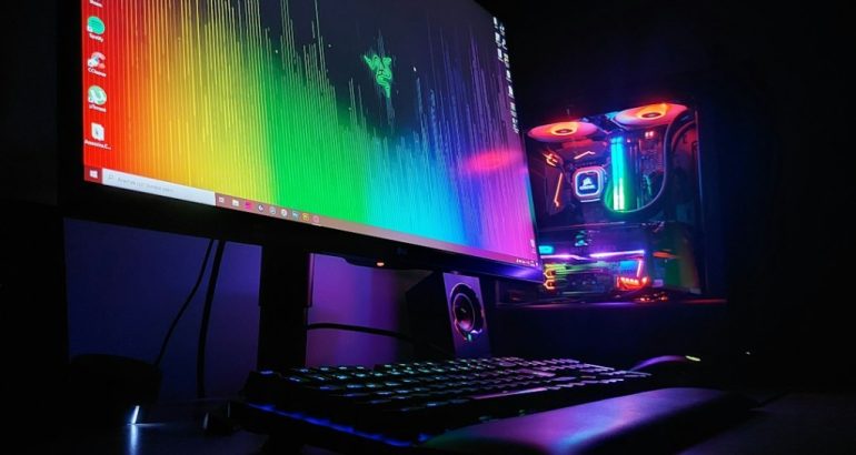 Computador gamer com monitor e teclado, ilustrando ajustes de FPS em jogos de PC